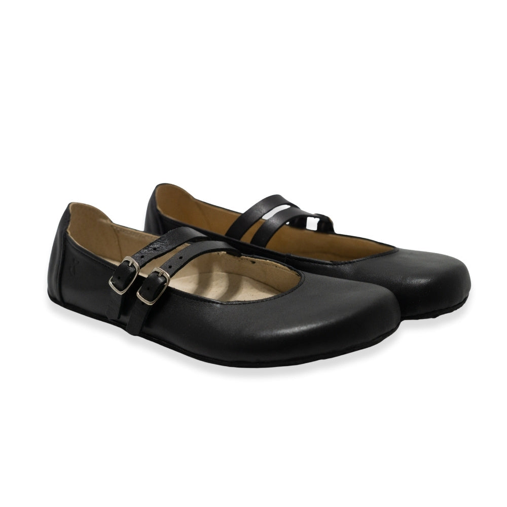 Black leather Villet Mary Jane flats with double straps with silver buckle closures, tan leather lining, and black rubber soles. Both shoes are shown facing diagonally right against a white background. #color_black-smooth