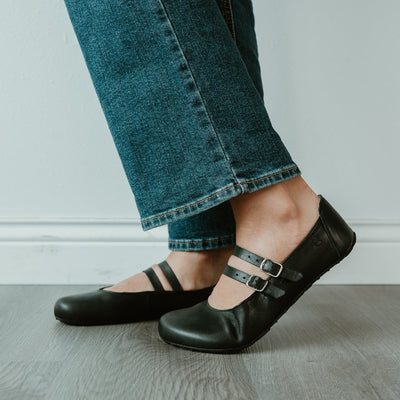 Black leather Villet Mary Jane flats with double straps with silver buckle closures, tan leather lining, and black rubber soles. #color_black-smooth