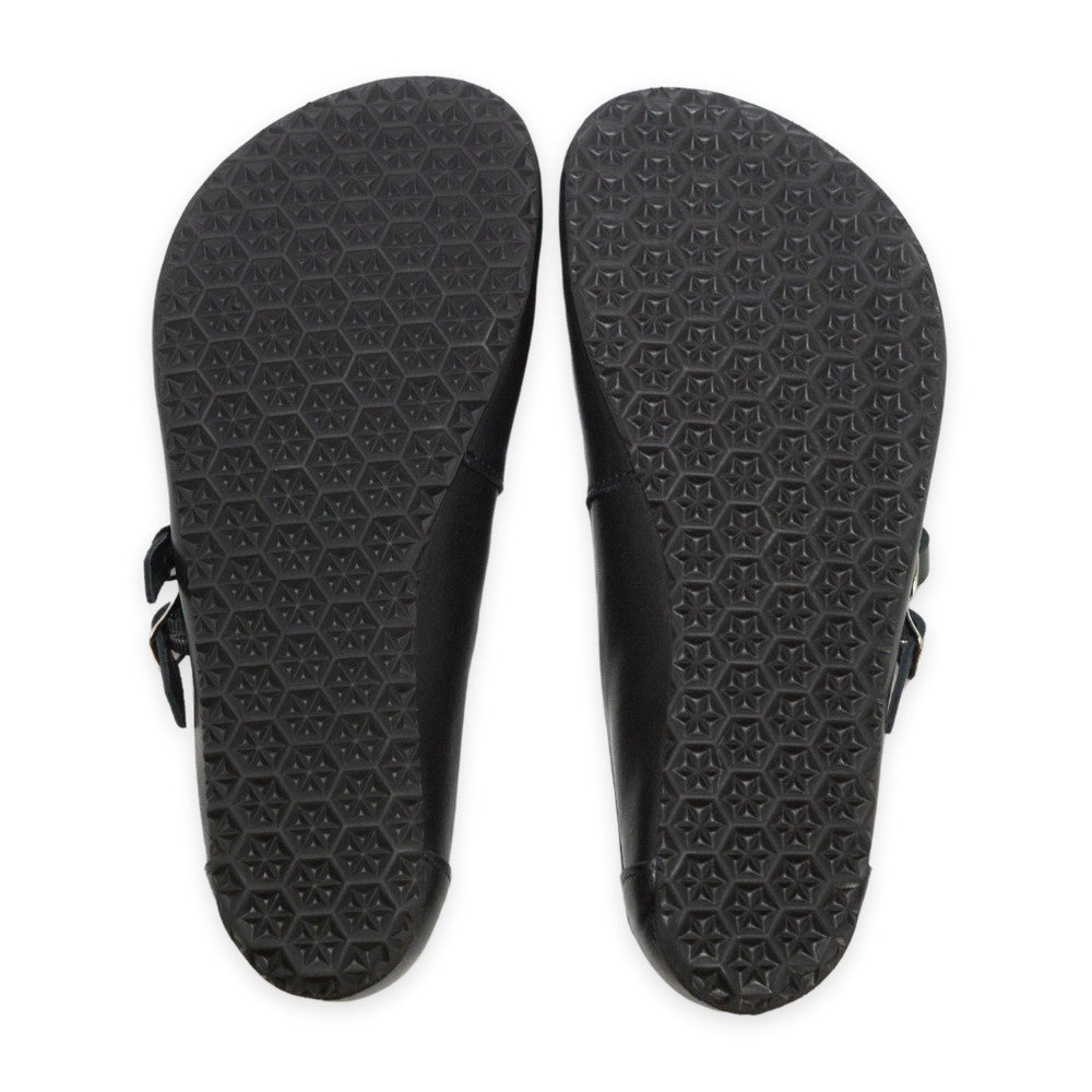 Black leather Villet Mary Jane flats with double straps with silver buckle closures, tan leather lining, and black rubber soles. Both shoe soles are shown from above against a white background. #color_black-smooth