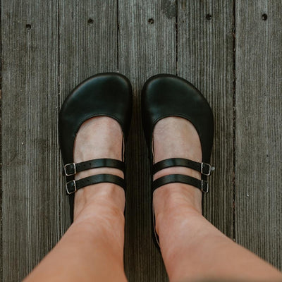 Black leather Villet Mary Jane flats with double straps with silver buckle closures, tan leather lining, and black rubber soles. #color_black-smooth
