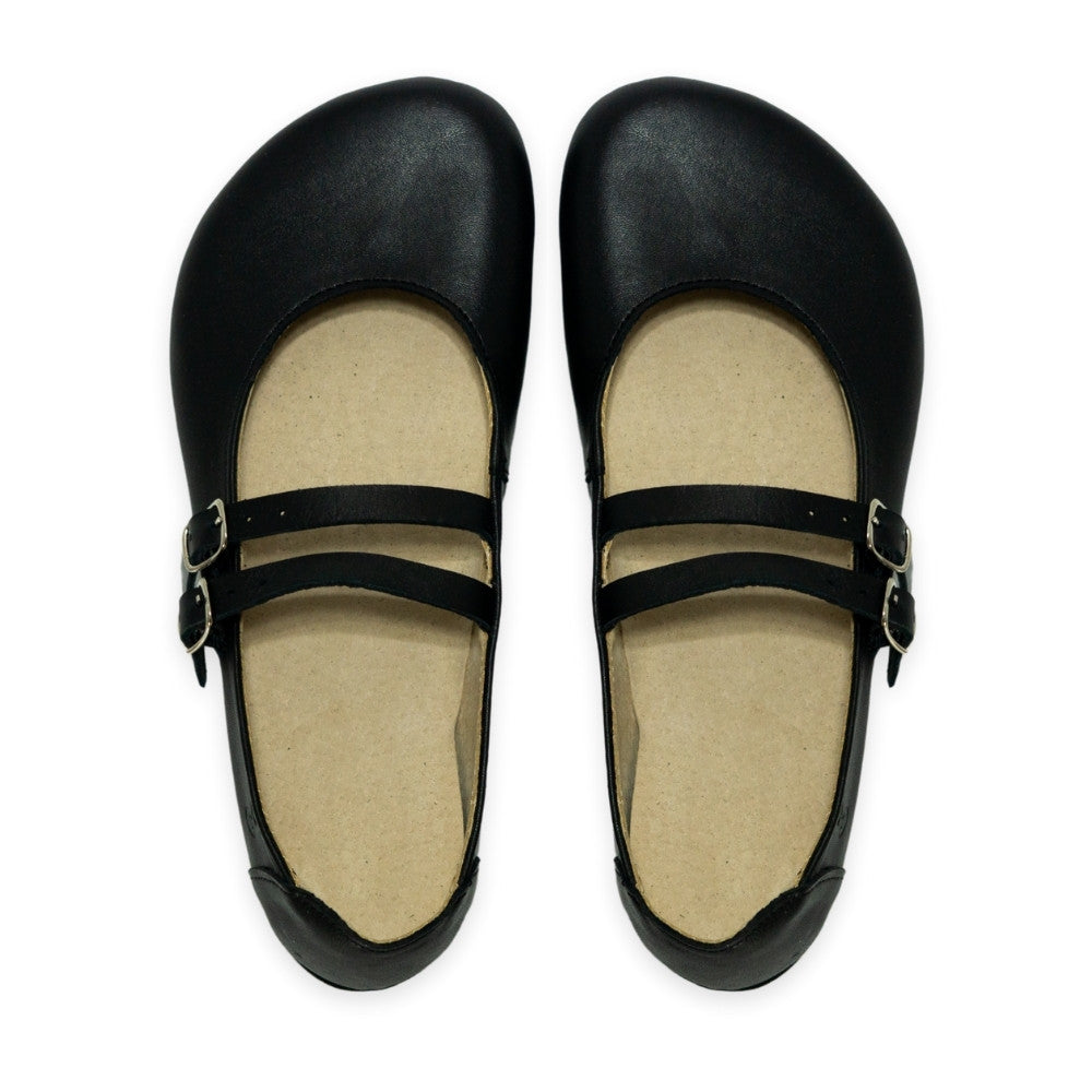 Black leather Villet Mary Jane flats with double straps with silver buckle closures, tan leather lining, and black rubber soles. Both shoes are shown from above against a white background. #color_black-smooth