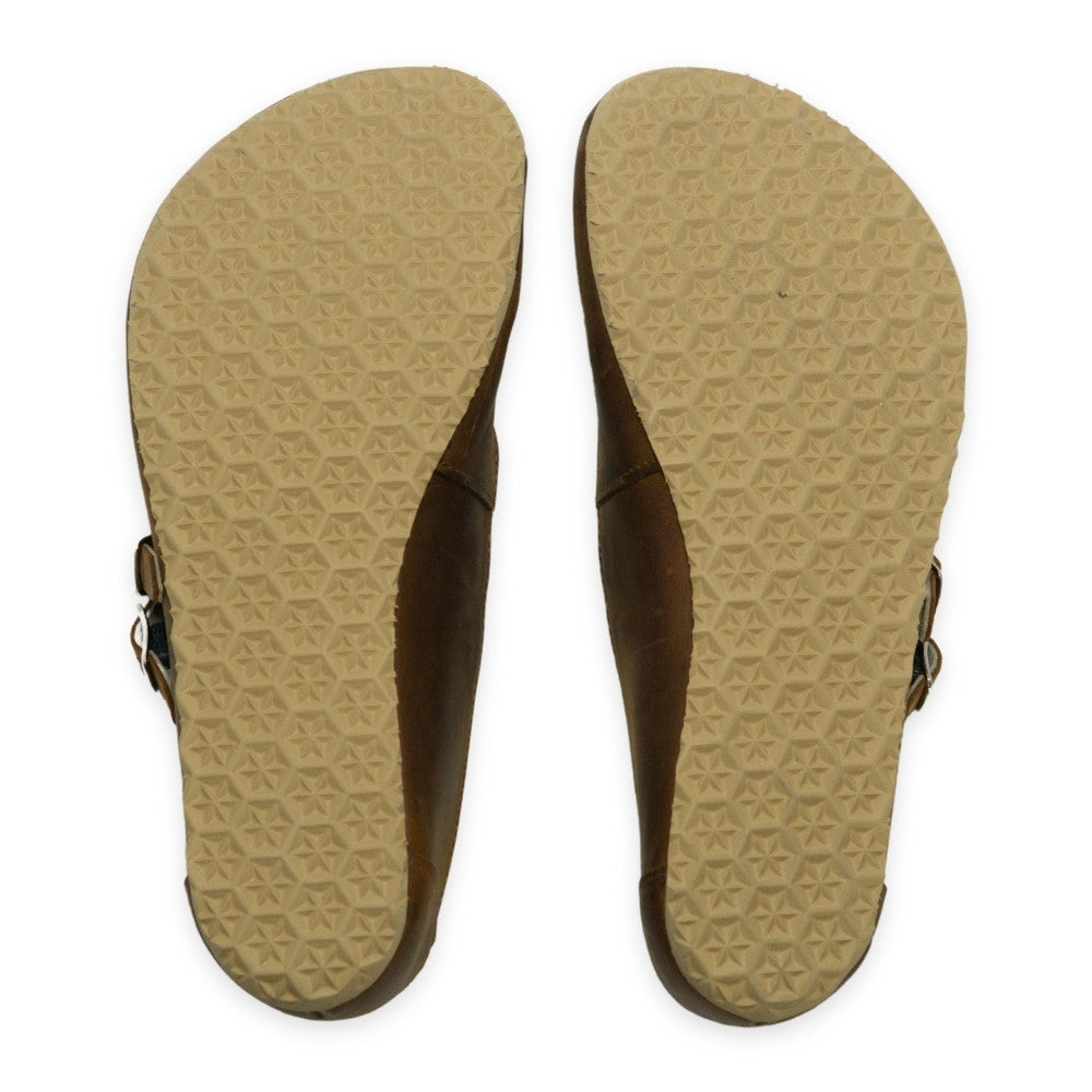 Brown nubuck leather Villet Mary Jane flats with double straps with silver buckle closures, tan leather lining, and tan rubber soles. Both shoe soles are shown from above against a white background. #color_brown-nubuck
