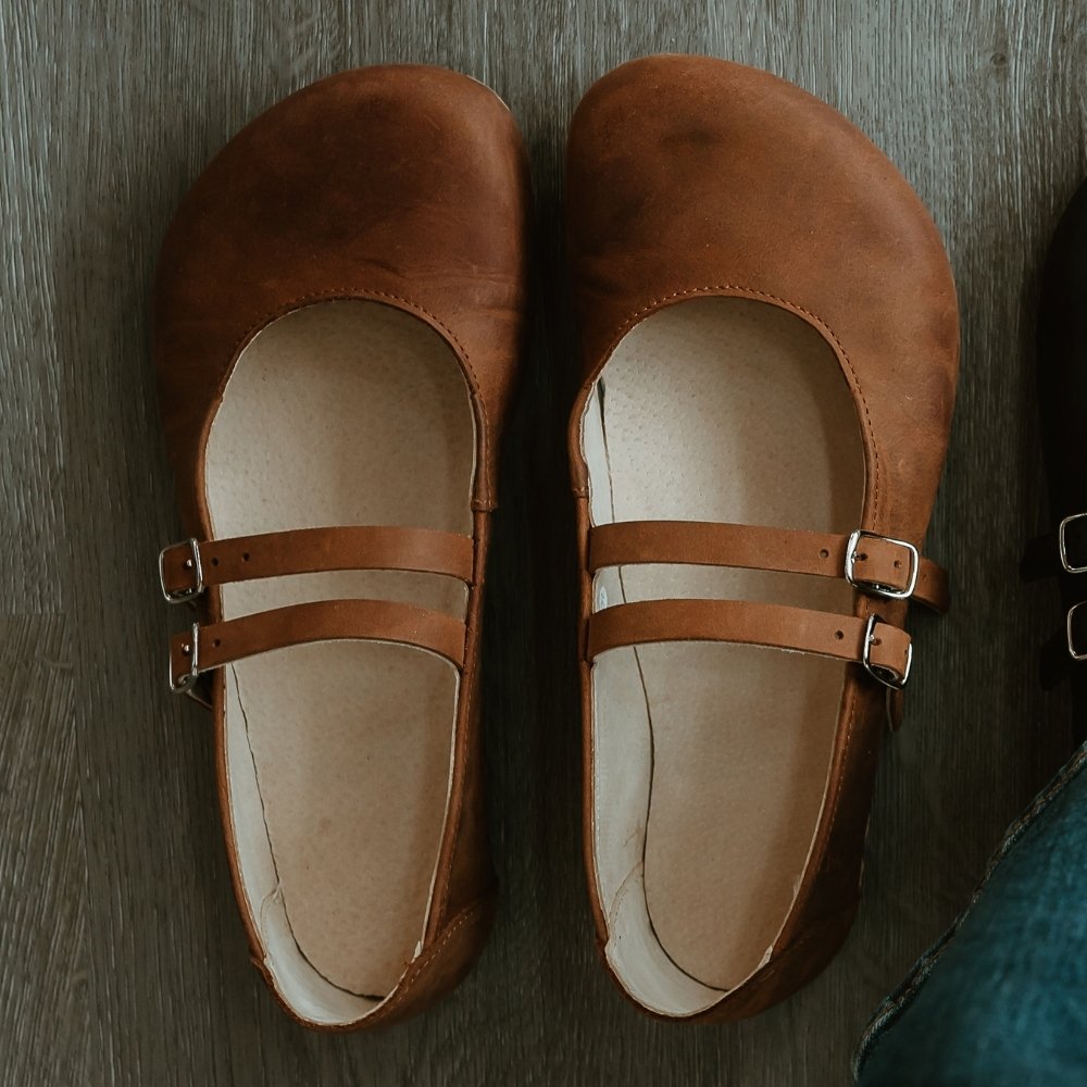 Brown leather Villet Mary Jane flats with double straps with silver buckle closures, tan leather lining, and beige rubber soles. #color_brown-nubuck