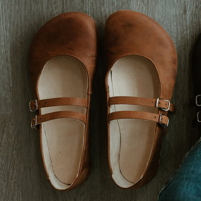 Brown leather Villet Mary Jane flats with double straps with silver buckle closures, tan leather lining, and beige rubber soles. #color_brown-nubuck