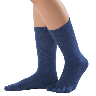 A pair of night blue Knitido crew-cut cotton & merino toe socks. Both socks are shown facing diagonally left against a white background on a person with the left heel up. #color_night-blue