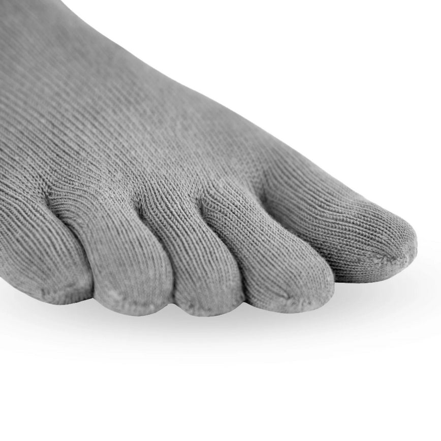 A photo of Knitido essential midi crew toe socks made with cotton, nylon, and elastane. The socks are a grey color. A close up is shown from the from the toes of the socks against a white background. #color_grey