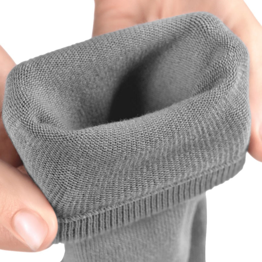 A photo of Knitido essential midi crew toe socks made with cotton, nylon, and elastane. The socks are a grey color. A woman’s hands are shown up close stretching the top of the socks while they are folded over against a white background. #color_grey