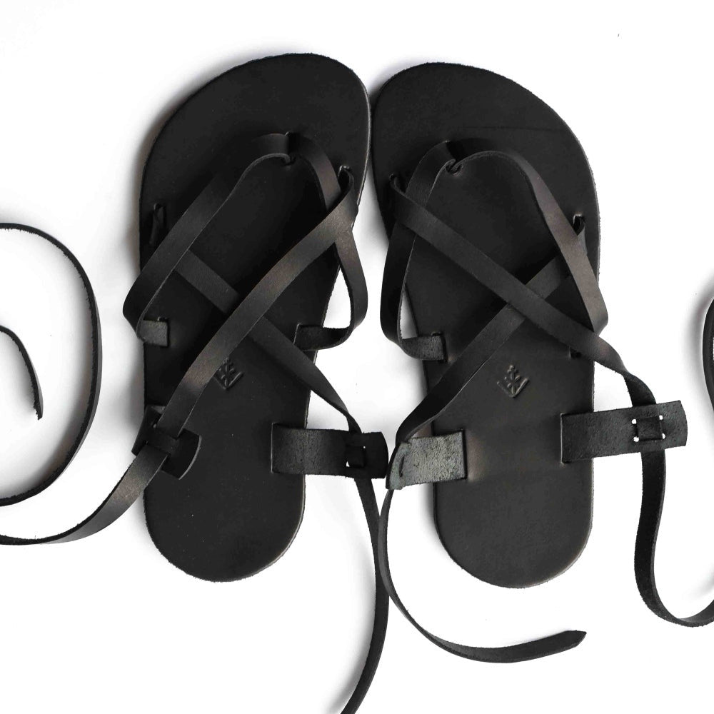 A black leather strappy sandal shown from above on a white background. #color_black