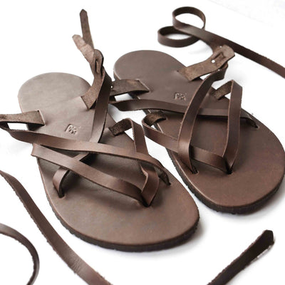 A brown leather strappy sandal shown close up facing diagonally right on a white background. #color_brown