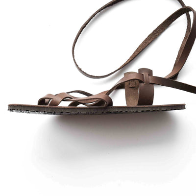 A brown leather strappy sandal shown from the side facing left on a white background. #color_brown