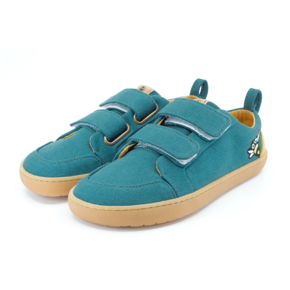 Abelha Dark Teal Mukishoes Play Kids shoe. Shoes are simple in design with velcro closures, an embroidered bee on the side close to the heel, a pull tab on the heel, a yellow color block on the heel, and yellow lining. Soles are a natural rubber gum color. Both shoes are shown here facing diagonally left against a white background. #color_abelha