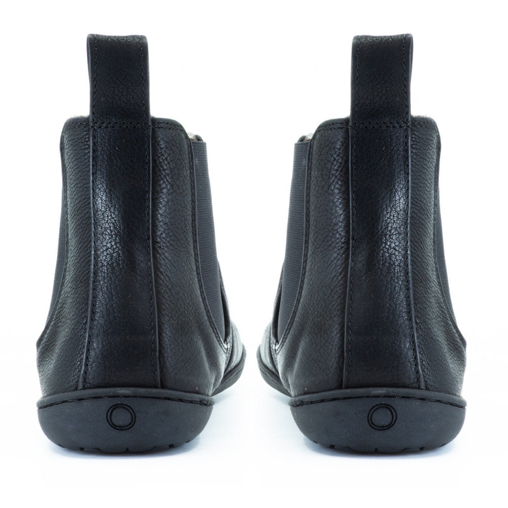 All black Mukishoes felted-wool-lined, leather Chelsea boots with elastic panels on both sides, a pull tab at the back/top of the opening, and a stitched, rubber sole. Both boots are shown from the back against a white background. #color_black