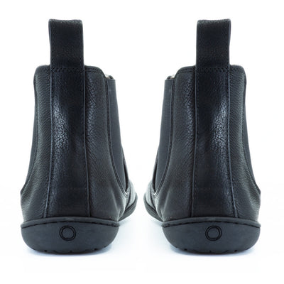 All black Mukishoes felted-wool-lined, leather Chelsea boots with elastic panels on both sides, a pull tab at the back/top of the opening, and a stitched, rubber sole. Both boots are shown from the back against a white background. #color_black