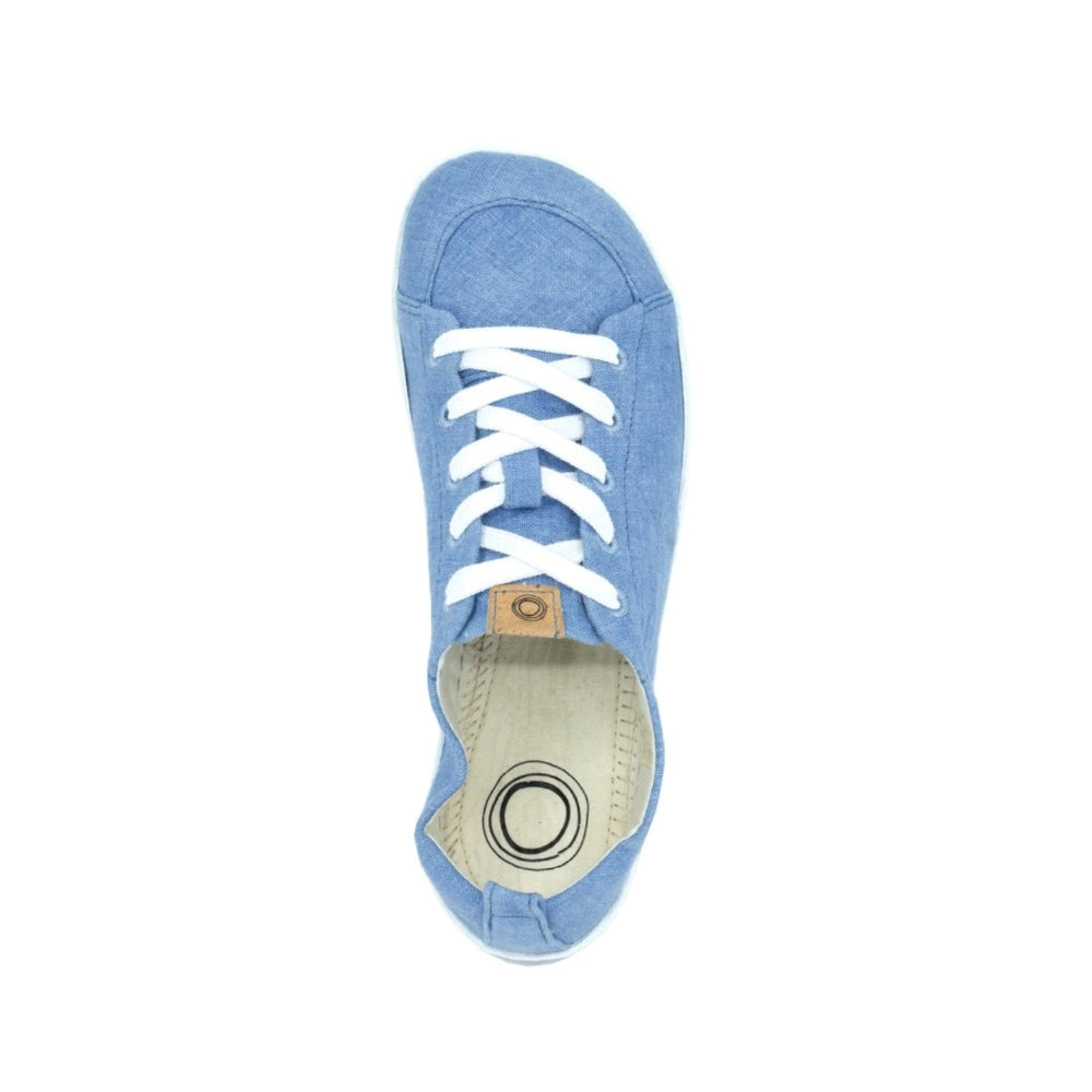 A photo of Mukishoes Indigo fabric sneakers. Shoes are simple in design, have a pull tab on the back, and white lining, laces, and soles. Right shoe is shown here from above against a white background. #color_indigo