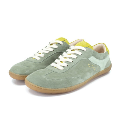 Theia (multiple green colors) Mukishoes Lyra suede leather sneakers with, white laces, and a natural rubber colored sole. Shoes are all sage green colored with a T-shaped detail on the toe box in sage green, a T-shaped seafoam green detail on both sides of the ankle, and neon green color detail on the top of the tongue and heel. Both shoes are shown here facing diagonally left against a white background. #color_theia
