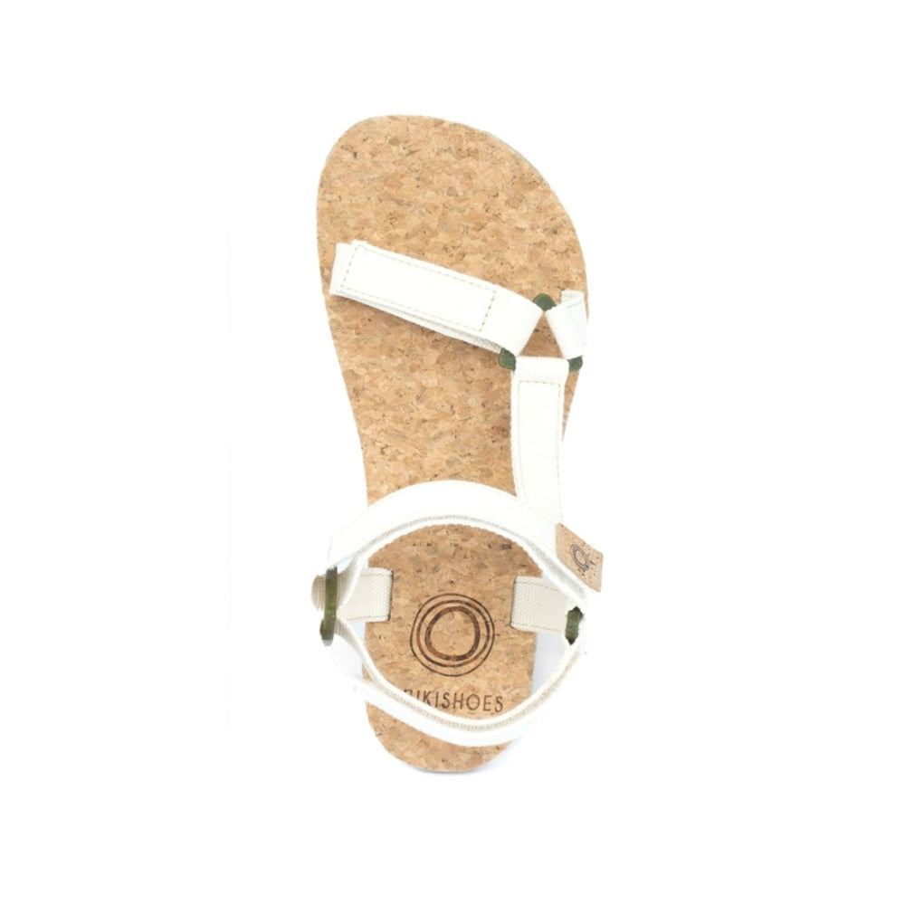 Cream Mukishoes Solstice. Sandals have thicker cotton adjustable straps going over the toes and surrounding the ankle with straps connecting the toe and ankle straps. Footbed is quark and sole is a thin black rubber. Right shoe is shown here from above against a white background. #color_natural-cream