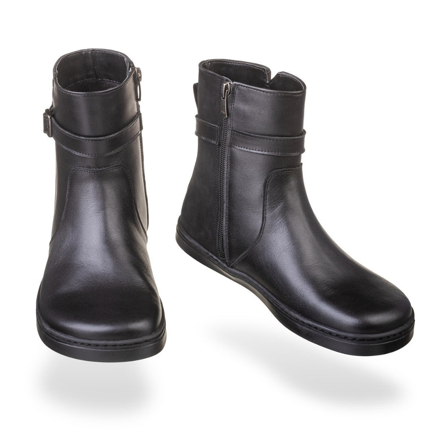 Peerko Glamour black leather ankle boots floating against white background, front view, with side zippers, ankle straps with buckles, and flat black soles. #color_black