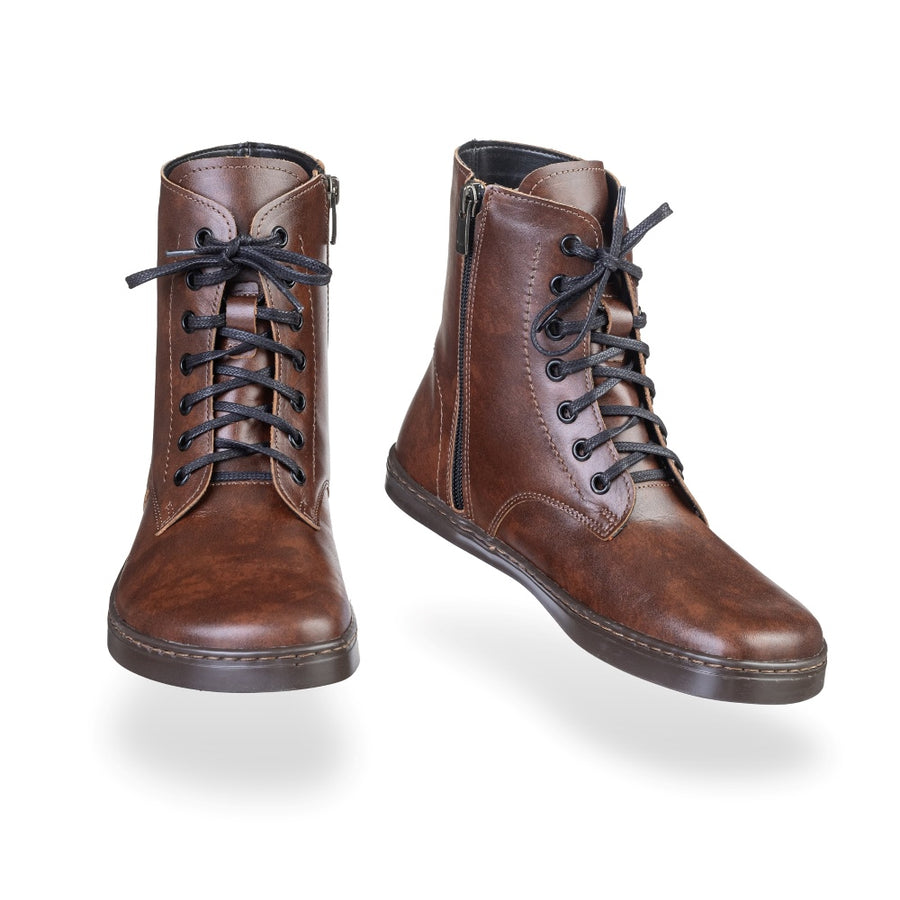 Brandy leather Peerko Go combat boots made with fleece lining, a black zipper, black laces, and black rubber soles. Both boots are shown floating forward angled slightly to the right against a white background. #color_brandy
