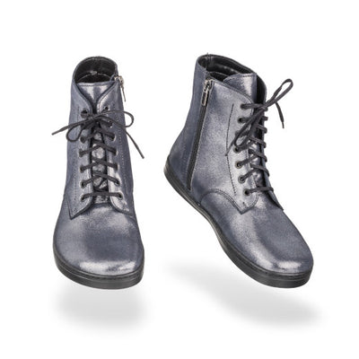 Dark silver leather Peerko Go combat boots made with fleece lining, a black zipper, black laces, and black rubber soles. Both boots are shown floating forward angled slightly to the right against a white background. #color_cosmic-silver