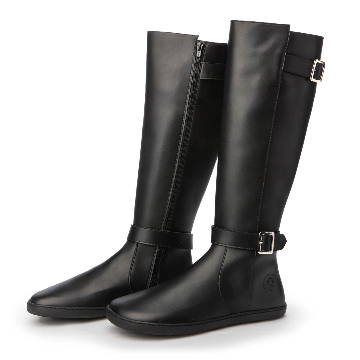 A photo of Shapen Glam lined riding boots made with leather, a faux fur lining, and rubber soles. The boots are black in color with zippers on the side and silver buckles on the top and around the ankle, the ankle buckle strap is removable. Both boots are shown from the right side beside each other angled slightly towards the front against a white background. #color_black