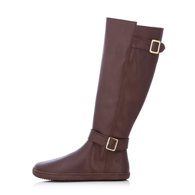 A photo of Shapen Glam lined riding boots made with leather, a faux fur lining, and brown rubber soles. The boots are brown in color with gold buckles on the top and around the ankle, the ankle buckle strap is removable. Left boot is shown facing left against a white background. #color_brown