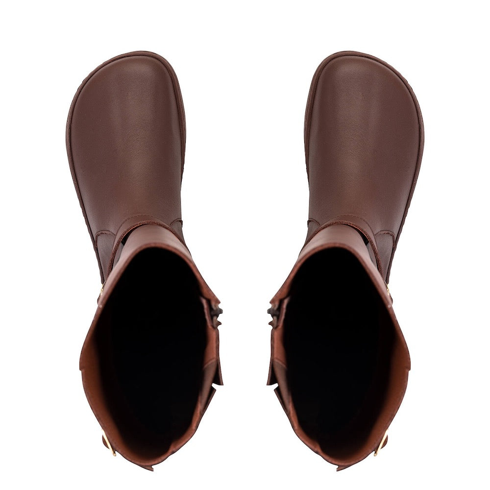 A photo of Shapen Glam lined riding boots made with leather, a faux fur lining, and brown rubber soles. The boots are brown in color with gold buckles on the top and around the ankle, the ankle buckle strap is removable. Both boots are shown from above against a white background. #color_brown