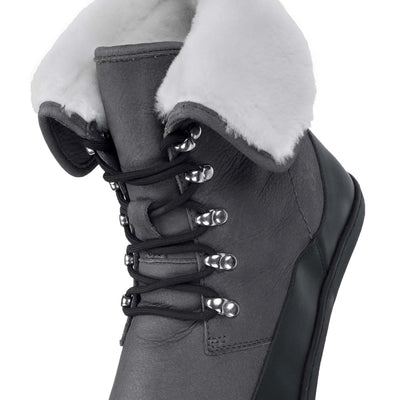 A photo of the Shapen Lynx lace up boots made from a water-resistant nubuck leather uppers and black rubber soles. The boots are dark grey in color, have a black leather rim around the bottom inch of the shoe, black laces, and a white wool lining that can be shown by folding over the top of the boots. The right boot is shown from above with the top of the boot folded down on a white background. #color_dark-grey
