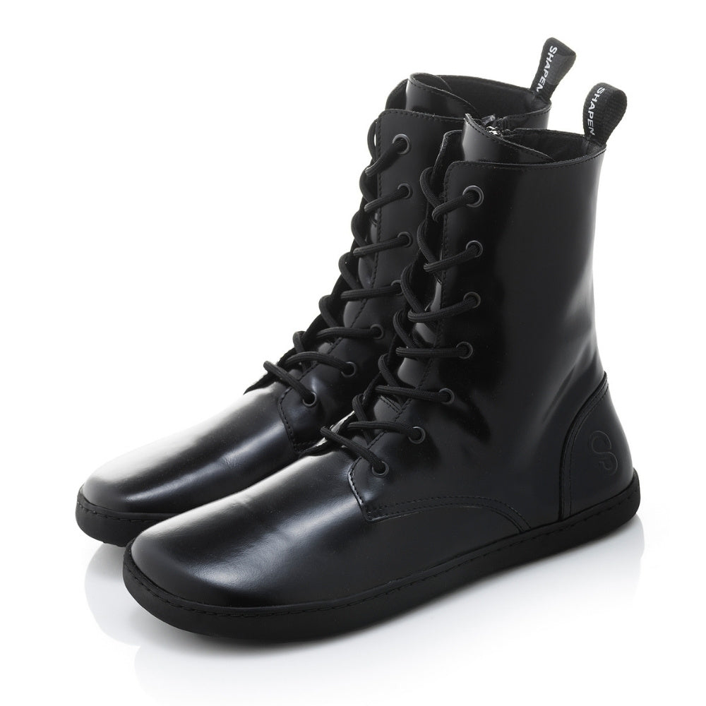 Black leather Shapen Maverick combat boots with a black, branded pull tab, a side zipper, black laces, and black rubber soles. Both shoes are shown facing diagonally left against a white background. #color_black