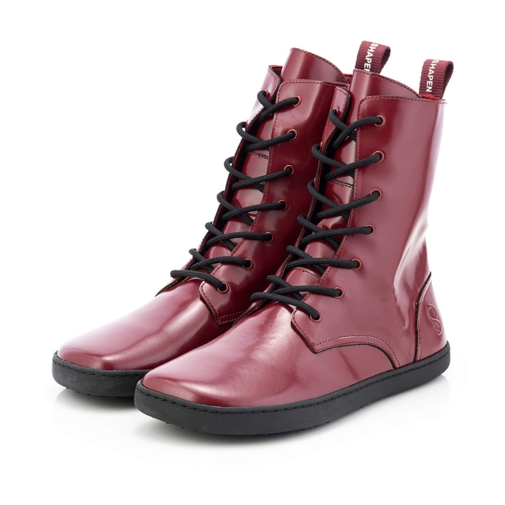 Dark red leather Shapen Maverick combat boots with a red, branded pull tab, a side zipper, black laces, and black rubber soles. Both shoes are shown facing diagonally left against a white background. #color_bordeaux