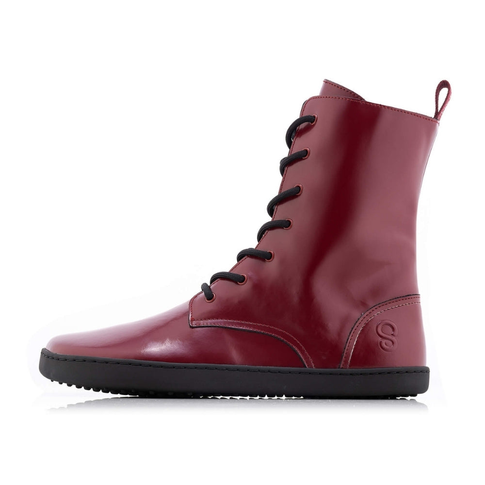 Dark red leather Shapen Maverick combat boots with a red, branded pull tab, a side zipper, black laces, and black rubber soles. Left shoe is shown facing left against a white background. #color_bordeaux