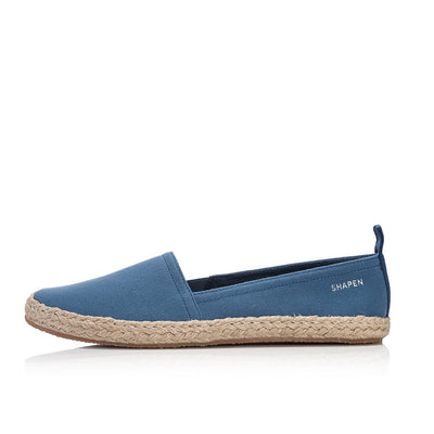 Indigo canvas Shapen Espadrilles loafers with a pull tab and tan soles. Left shoe is shown facing left against a white background. #color_indigo