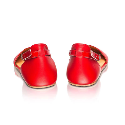 A photo of Shapen Poppy D’orsay dressy flats with a leather upper and rubber soles. The flats are a cherry red color with a heel cup and dainty ankle strap, the inside of the sole are a beige color. Both flats are shown from the back against a white background. #color_red