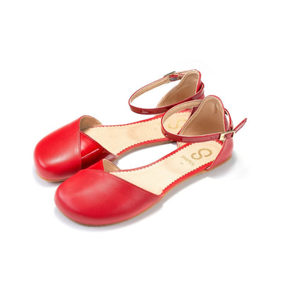 Red leather Shapen Poppy D’orsay dressy flats with a tan footbed and tan rubber soles. The flats have a heel cup held on by a dainty, patent leather ankle strap. Both flats are shown facing diagonally left against a white background. #color_cherry