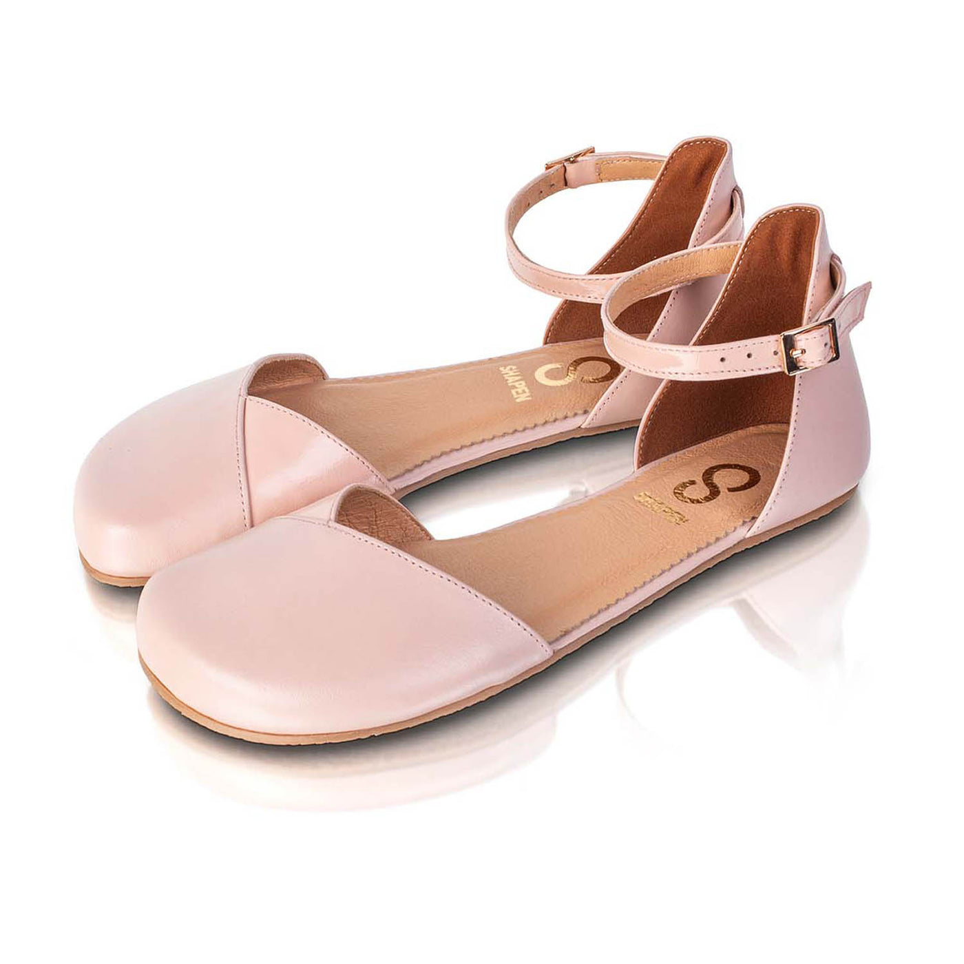 A photo of Shapen Poppy D’orsay dressy flats with a leather upper and rubber soles. The flats are a rose beige color with a heel cup and dainty ankle strap, the inside of the sole are a beige color. Both flats are shown beside each other turned with the right shoe towards the front against a white background. #color_rose