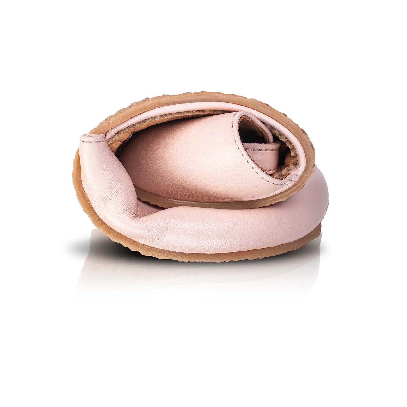 A photo of Shapen Poppy D’orsay dressy flats with a leather upper and rubber soles. The flats are a light rose color with a heel cup and dainty ankle strap, the inside of the sole are a beige color. The right shoe is shown rolled in a ball against a white background. #color_rose