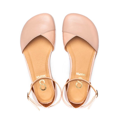 A photo of Shapen Poppy D’orsay dressy flats with a leather upper and rubber soles. The flats are a rose beige color with a heel cup and dainty ankle strap, the inside of the sole are a beige color. Both flats are shown from the top facing up against a white background. #color_rose