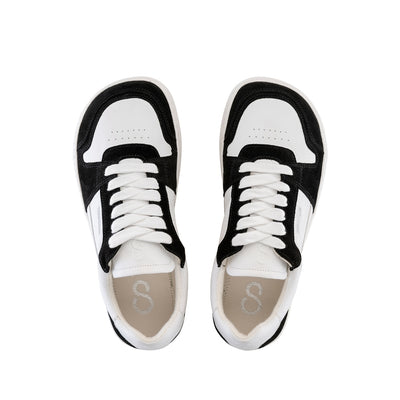 A photo of Shapen ReWind leather sneakers in white & black. Shoes are a classic chunky sneaker design with black suede color blocks surrounding the toe guard, laces, and heels. Both shoes are shown here from the top down against a white background. #color_black-white