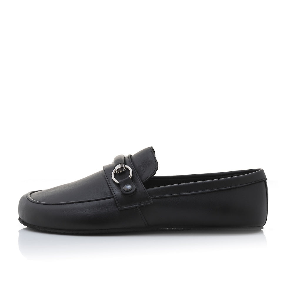 Black leather Shapen Versa loafers. Shoes are a classic loafer design with a leather decoration capped by silver metal rings across the foot and black rubber soles glued on. Left shoe is shown facing left against a white background. #color_black