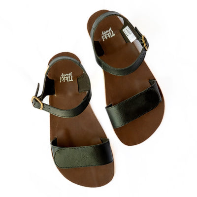 Tikki Vibe black vegan sandals with tan soles and a brown footbed. A thick velcro strap secures the foot at the toes with a slimmer ankle buckle-closure strap in the back. Both shoes are shown staggered here from above against a white background. #color_onyx-vegan