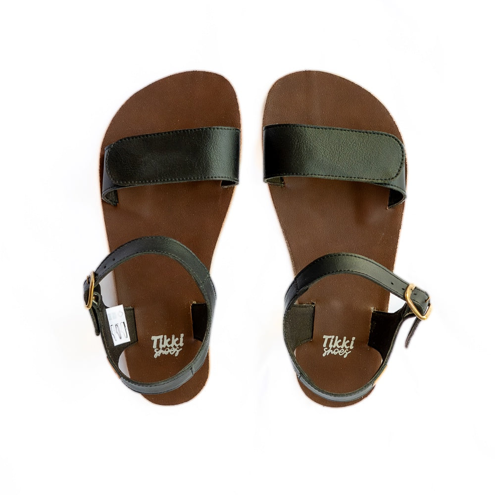 Tikki Vibe black vegan sandals with tan soles and a brown footbed. A thick velcro strap secures the foot at the toes with a slimmer ankle buckle-closure strap in the back. Both shoes are shown here from above against a white background. #color_onyx-vegan