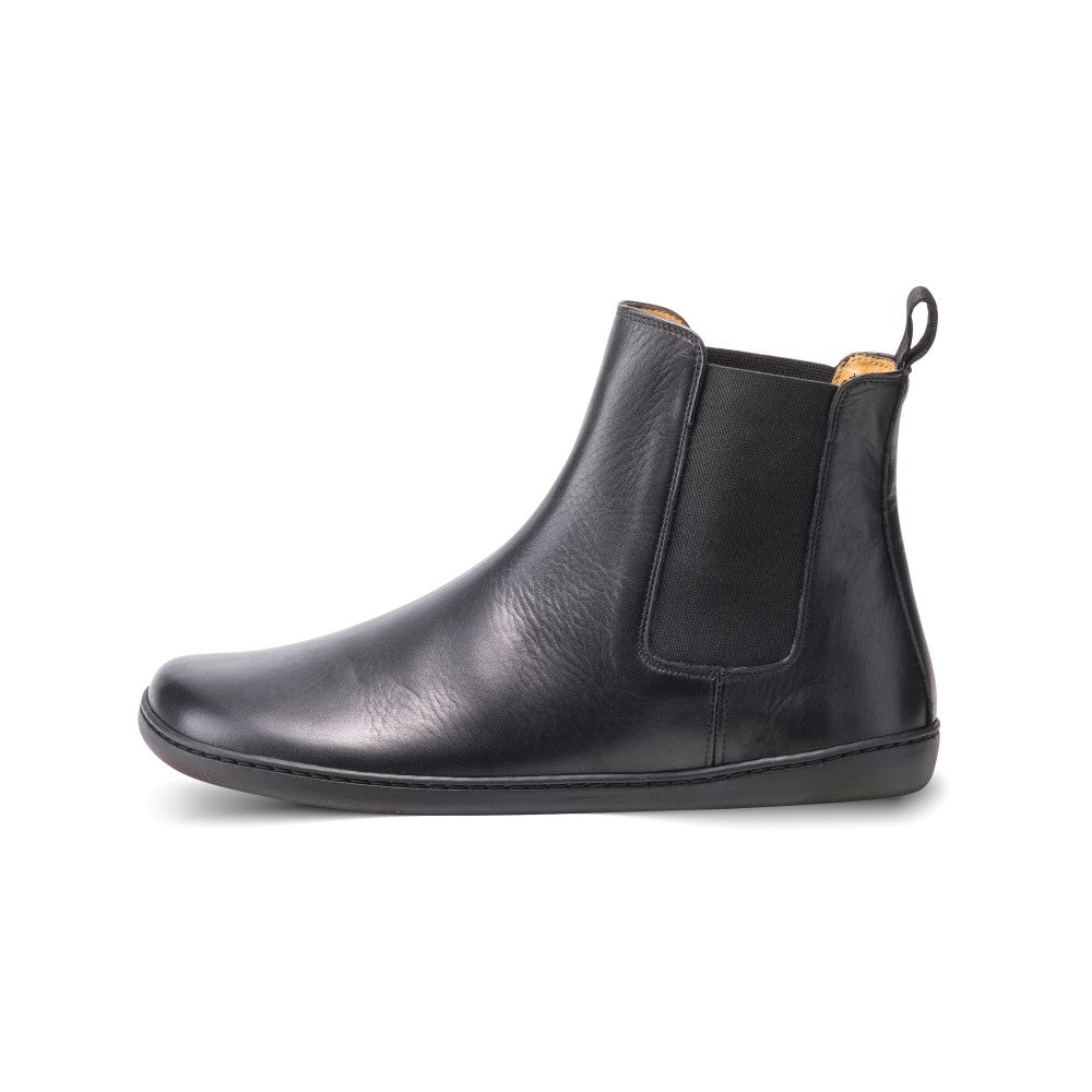 Smooth black leather Zaqq Equity unlined Chelsea boots. Lining is a camel color. A pull tab is present at the back of the boot opening. Left shoe is shown here facing left against a white background. #color_black