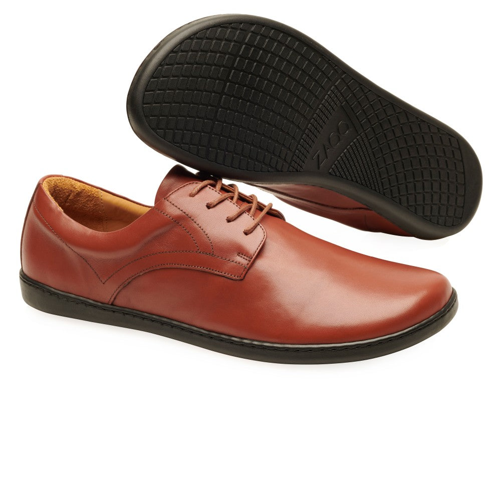 Cognac Zaqq Peaq leather dress shoes with coganc laces and black rubber soles. Right shoe is shown facing right with the left shoe sole leaning on it against a white background. #color_cognac