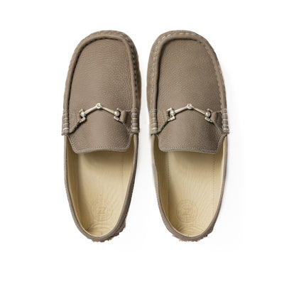 A photo of the Zeazoo Cheetah loafers made from a natural nappa leather upper on a tan Vibram sole. The loafers are stone in color and have a silver metal detail across the top of the foot. Both loafers are shown together from above on a white background. #color_stone
