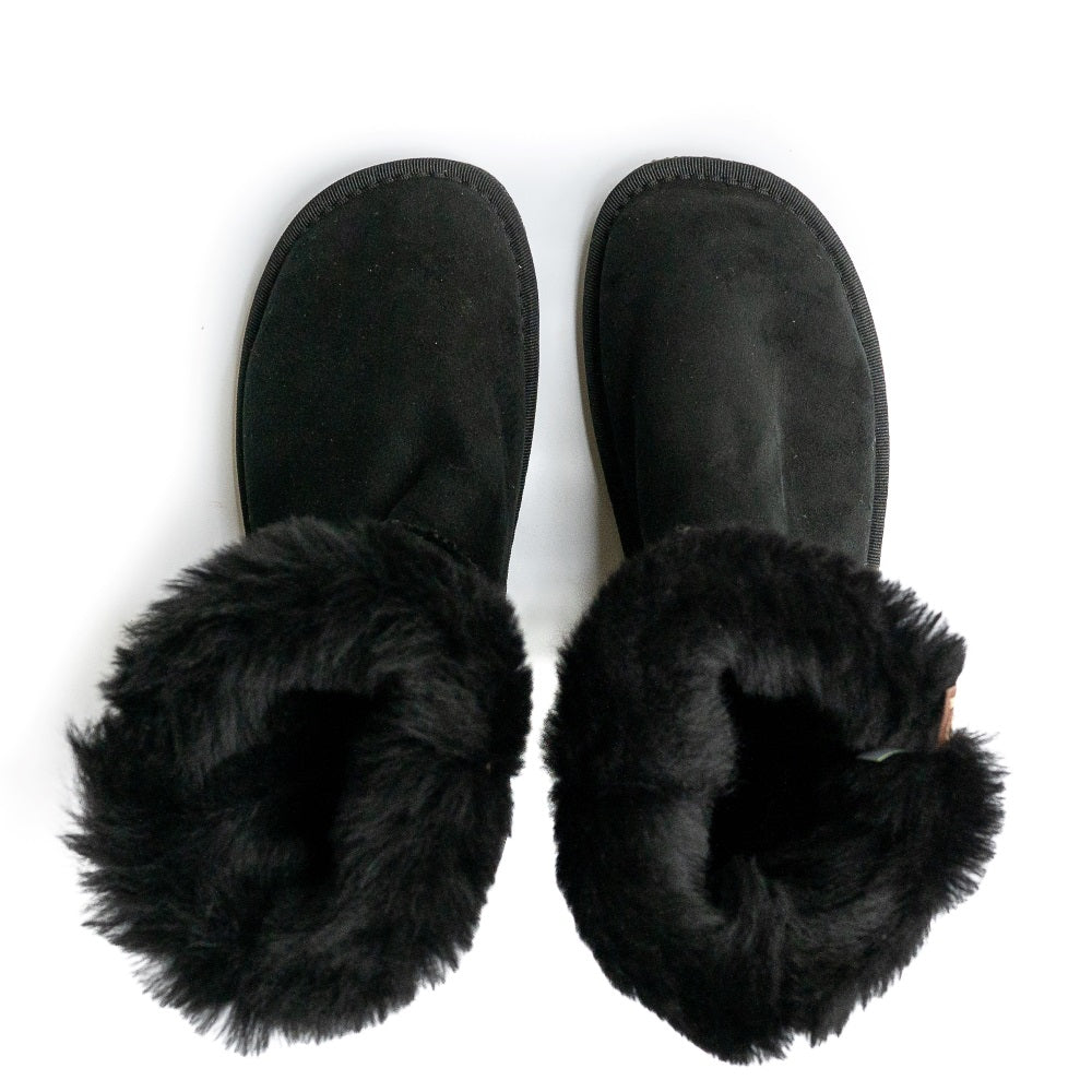 A photo of Zeezoo Dingo made with suede, sheepskin, and rubber soles. The boots are black in color with black soles and an ugg style look. Both boots are shown from the top down with the lining folded out and exposed against a white background. #color_black