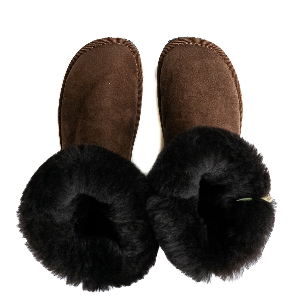 A photo of Zeezoo Dingo made with suede, sheepskin, and rubber soles. The boots are brown in color with black soles and an ugg style look. Both boots are shown from the top down with the lining folded out and exposed against a white background. #color_brown