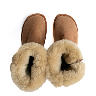 A photo of Zeezoo Dingo made with suede, sheepskin, and rubber soles. The boots are brown in color with tan soles and an ugg style look. Both boots are shown from the top down with the lining folded out and exposed against a white background. #color_chestnut