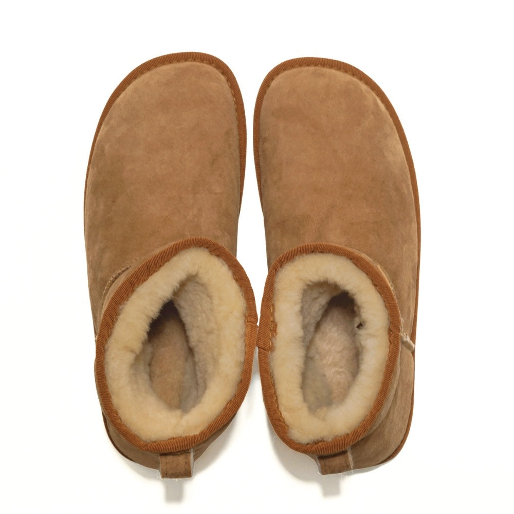 A plain light-brown Zeazoo Dingo Mini sheepskin ankle boot with a back pull tab, cream wool lining, and cream rubber vibram soles. Both shoes are shown from above against a white background. #color_chestnut