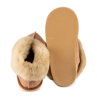 Chestnut colored Zeezoo Dolly hand made suede, sheepskin, and tan rubber slippers. The slippers are composed of 4 panels sewn together with seams on the sides, back, and top. Fur lining folds over at the ankle. Left slipper is shown from the back next to the right slipper sole facing up against a white background. #color_chestnut