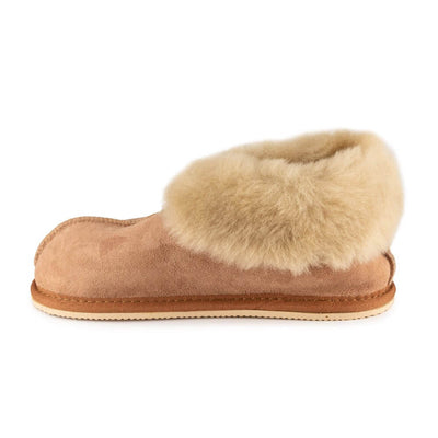 Chestnut colored Zeezoo Dolly hand made suede, sheepskin, and tan rubber slippers. The slippers are composed of 4 panels sewn together with seams on the sides, back, and top. Fur lining folds over at the ankle. Right slipper is shown facing left against a white background. #color_chestnut