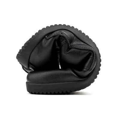 A photo of Ahinsa Jaya boots made from faux leather and rubber soles. The boots are black in color the fit is mid calf and they have laces all the way up. One boot is shown rolled into a ball to show the flexibility against a white background. #color_black